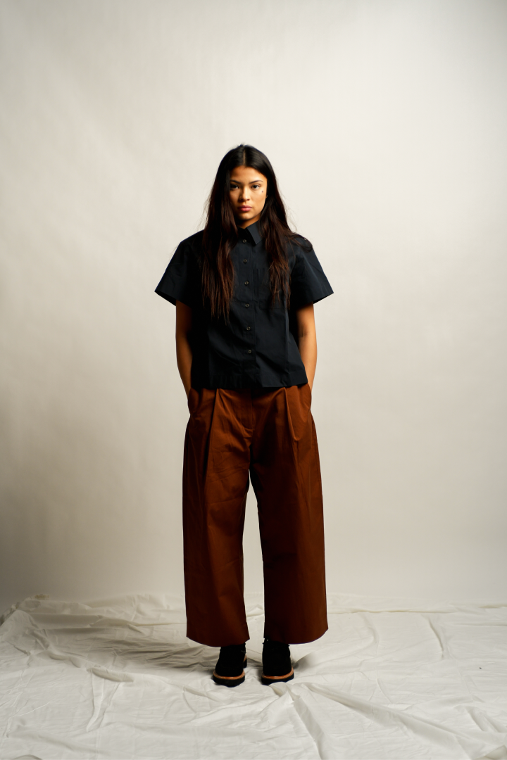 Woman wearing button down and pleated pants